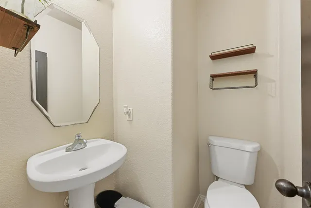 a bathroom with a toilet sink and mirror