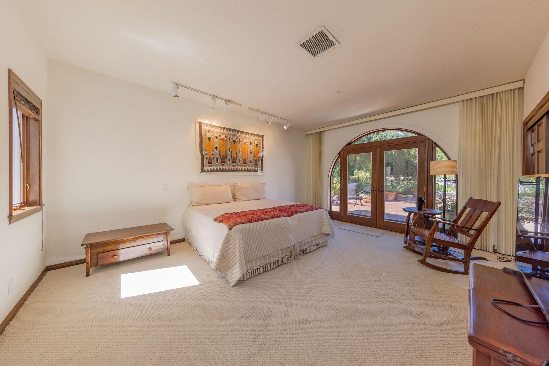 10883 Oak Knoll Road Ojai, CA 93023 - Photo 23 of 43 a spacious bedroom with a bed a couch and a window