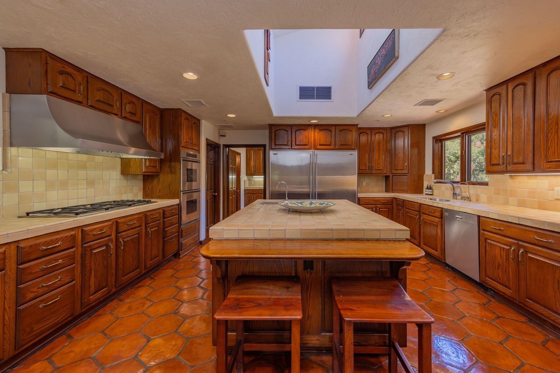 10883 Oak Knoll Road Ojai, CA 93023 - Photo 25 of 43 a kitchen with stainless steel appliances granite countertop a table chairs sink and cabinets