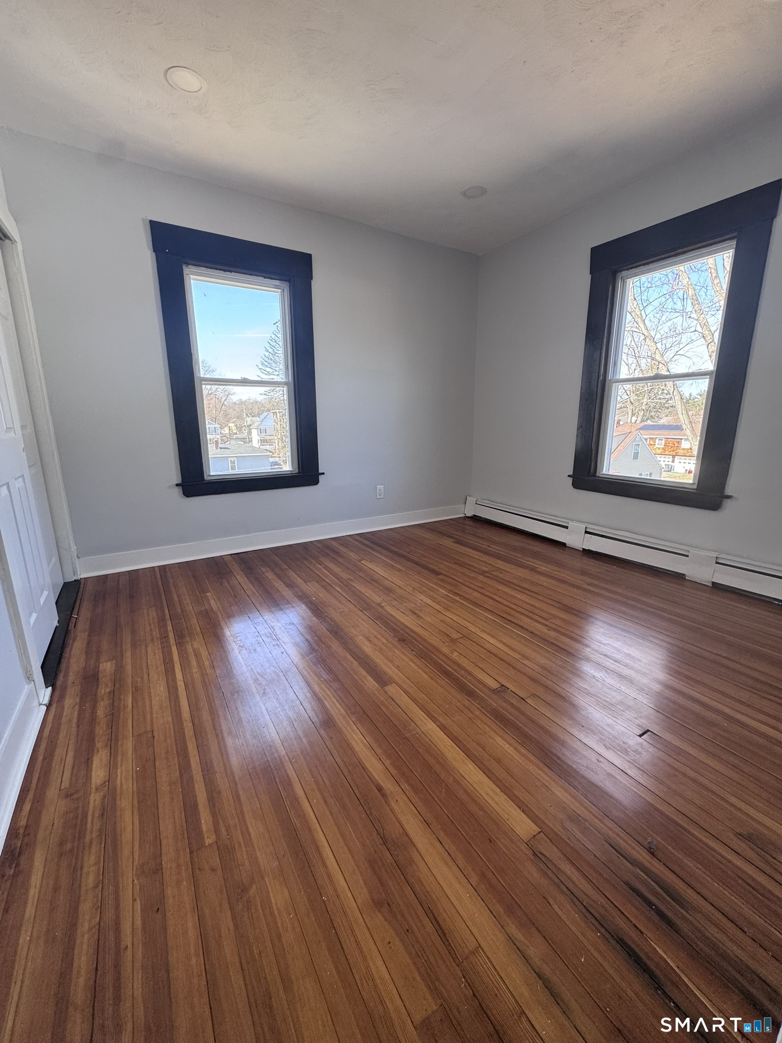 283 Martin Street Hartford, CT 06120 - Photo 11 of 16 an empty room with wooden floor and windows