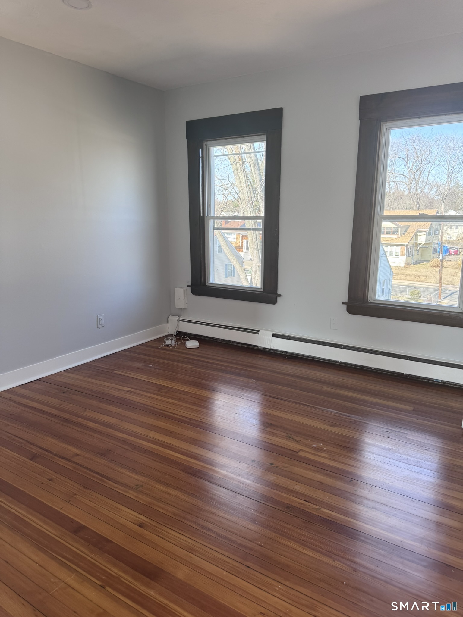283 Martin Street Hartford, CT 06120 - Photo 3 of 16 an empty room with wooden floor and windows