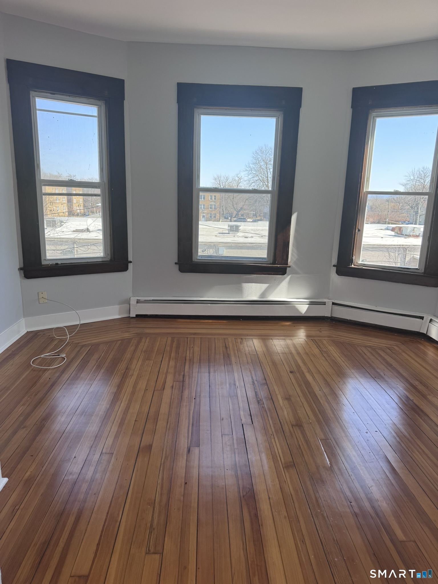 283 Martin Street Hartford, CT 06120 - Photo 4 of 16 a view of an empty room with wooden floor and a window