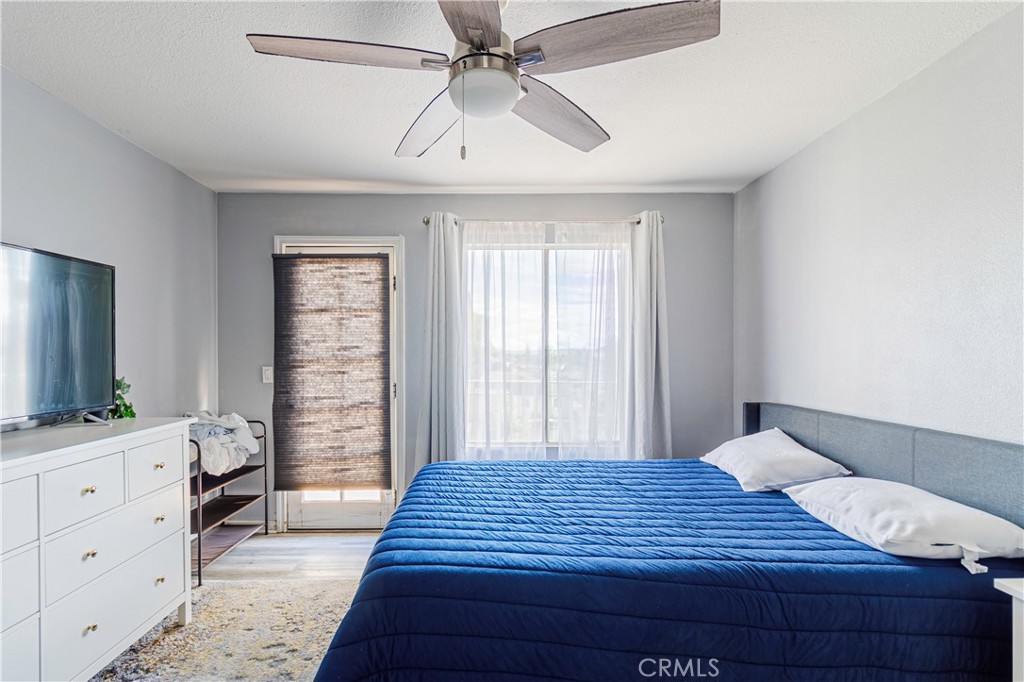 874 Cinnamon Lane, Unit 62 Duarte, CA 91010 - Photo 9 of 22 a bedroom with a large bed and a flat tv screen on dresser