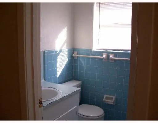 a bathroom with a toilet a sink a window and mirror