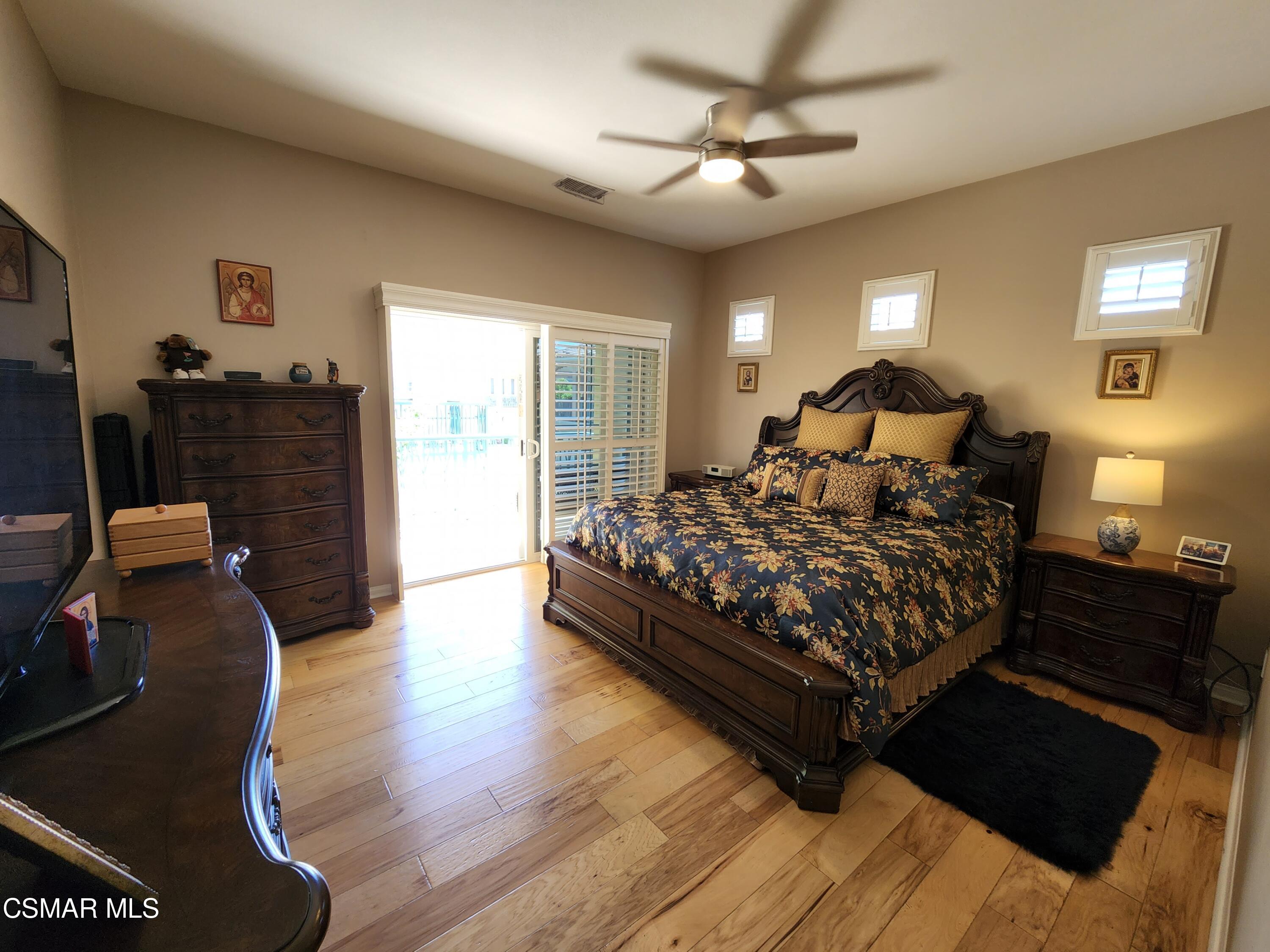 4121 Paredo Way, Unit D Simi Valley, CA 93063 - Photo 25 of 35 a bedroom with a bed lamp and wooden floor