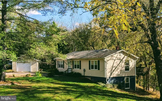 a front view of a house with a garden and trees