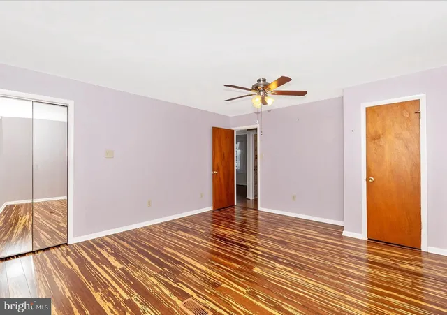 a view of a livingroom with wooden floor and a ceiling fan