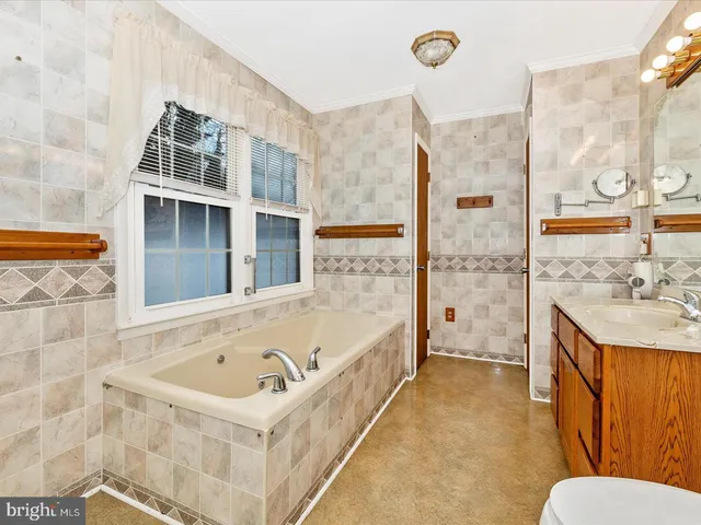a bathroom with a tub sink and mirror
