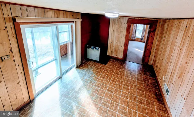 a view of a livingroom with an entryway and a ceiling fan