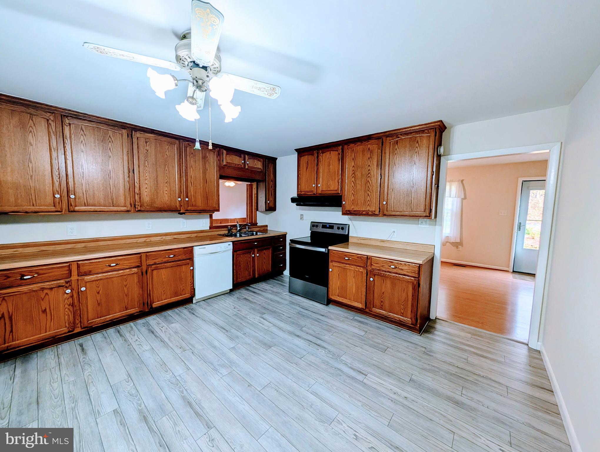 7403 Bear Branch Road Adamstown, MD 21710 - Photo 6 of 43 a kitchen with wooden floors and wooden cabinets