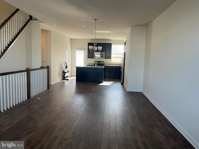 a living room with wooden floors and kitchen view