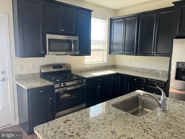 a kitchen with a sink stove top oven and cabinets