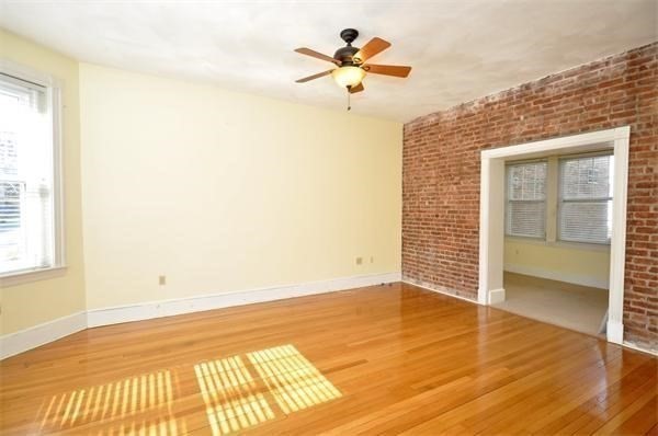 96 St Paul Street, Unit 2 Brookline, MA 02446 - Photo 4 of 14 an empty room with wooden floor and a window