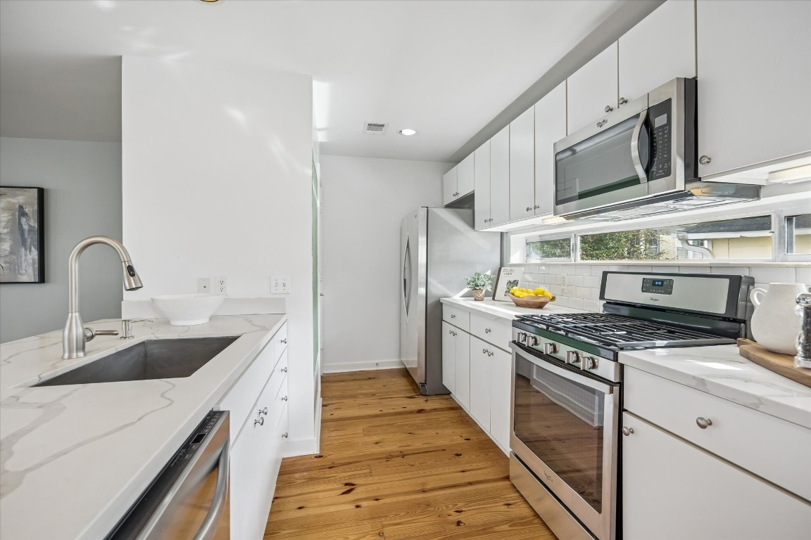 2508 Calumet Street, Unit E Houston, TX 77004 - Photo 8 of 31 a kitchen with stainless steel appliances granite countertop a sink and a stove