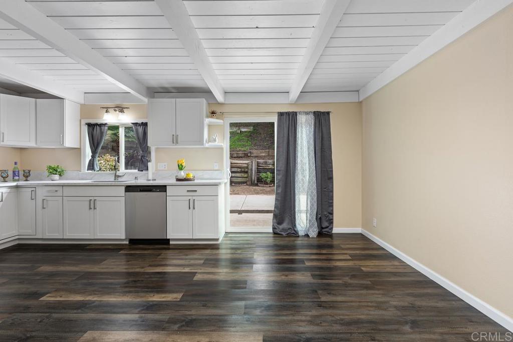 921 Lemon Avenue Vista, CA 92084 - Photo 15 of 32 a kitchen with granite countertop wooden floors and white cabinets