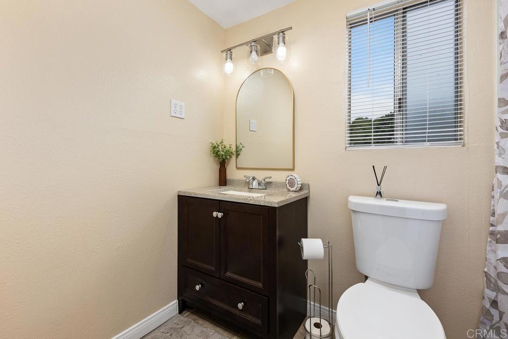 921 Lemon Avenue Vista, CA 92084 - Photo 19 of 32 a bathroom with a toilet sink and mirror