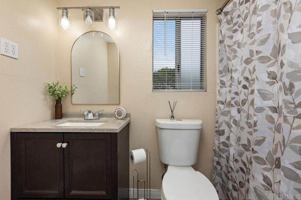 921 Lemon Avenue Vista, CA 92084 - Photo 20 of 32 a bathroom with a toilet sink and mirror