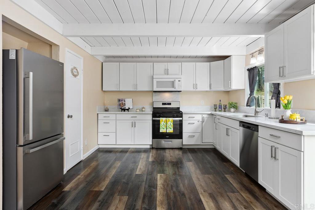 921 Lemon Avenue Vista, CA 92084 - Photo 9 of 32 a kitchen with white cabinets and stainless steel appliances