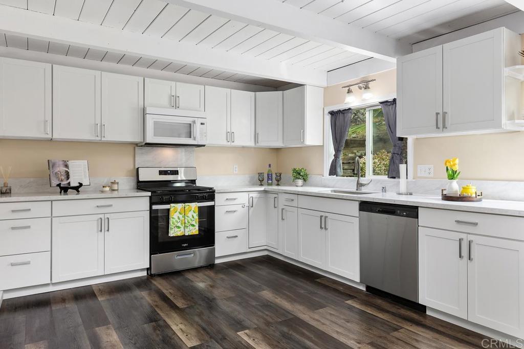 921 Lemon Avenue Vista, CA 92084 - Photo 10 of 32 a kitchen with granite countertop white cabinets and white appliances