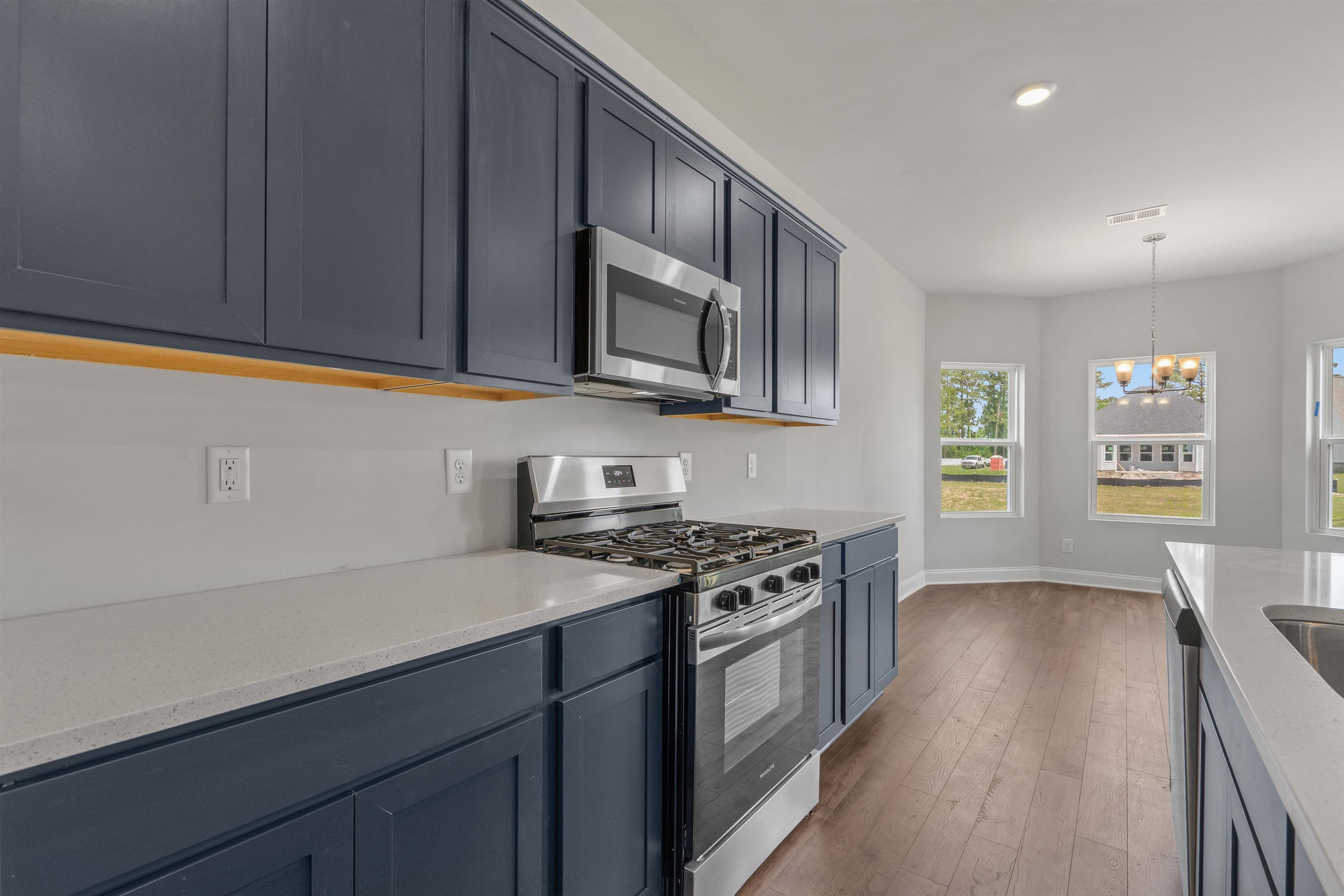 2495 Campton Loop Conway, SC 29527 - Photo 2 of 27 Kitchen featuring appliances with stainless steel finishes, hanging light fixtures, dark wood-type flooring, light stone counters, and recessed lighting
