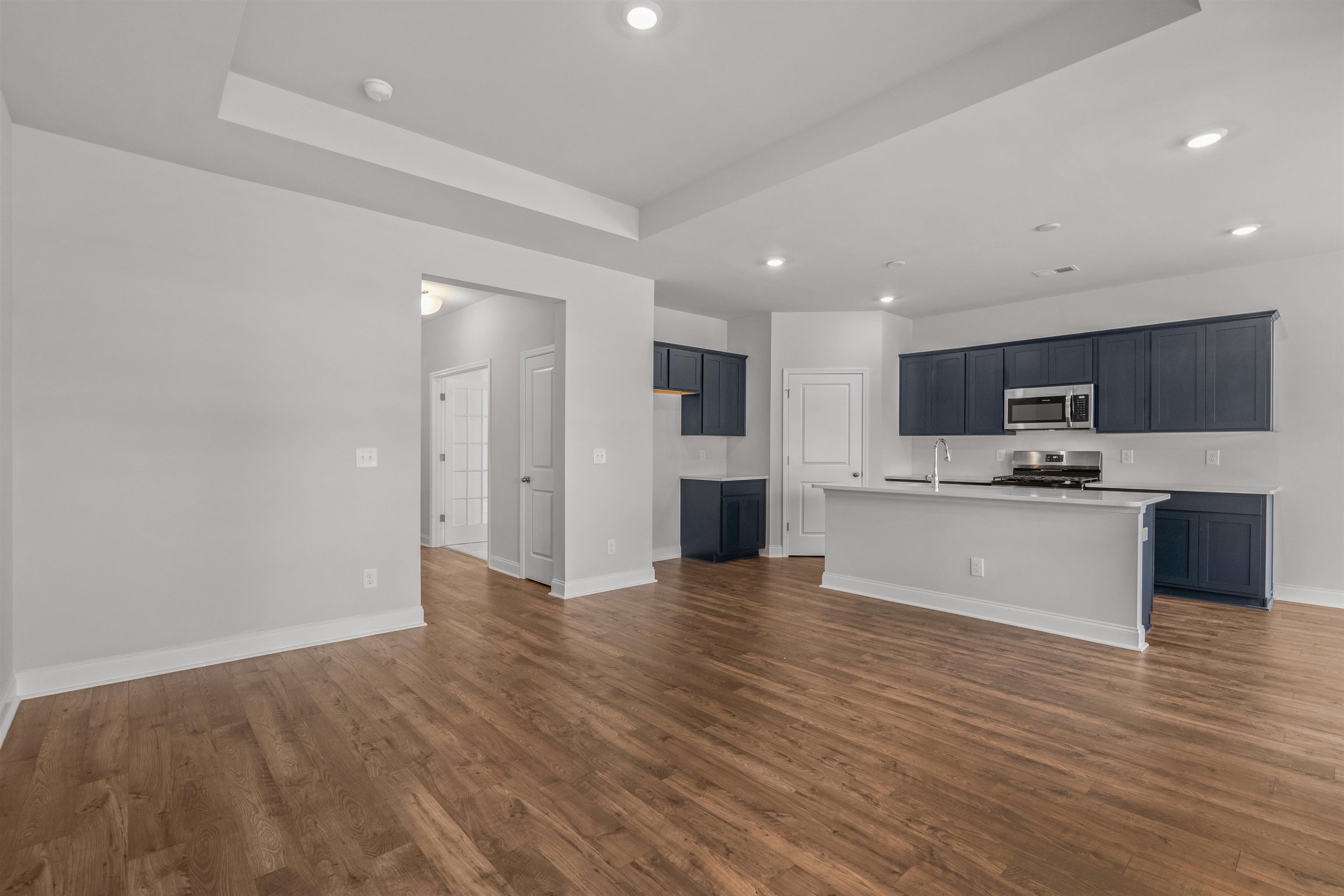 2495 Campton Loop Conway, SC 29527 - Photo 26 of 27 Kitchen featuring a raised ceiling, appliances with stainless steel finishes, a kitchen island with sink, dark wood finished floors, and open floor plan