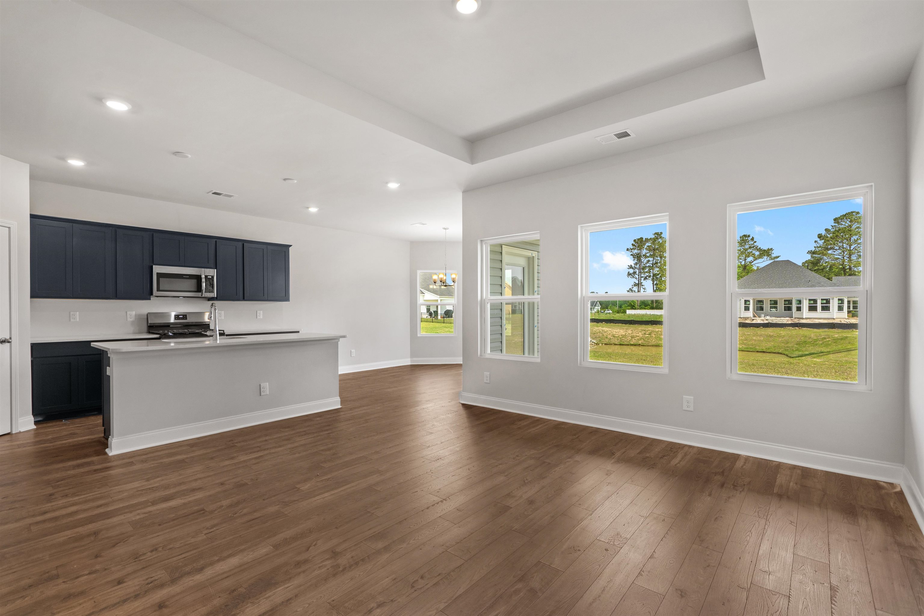 2495 Campton Loop Conway, SC 29527 - Photo 27 of 27 Kitchen with an island with sink, appliances with stainless steel finishes, dark wood-type flooring, open floor plan, and a chandelier