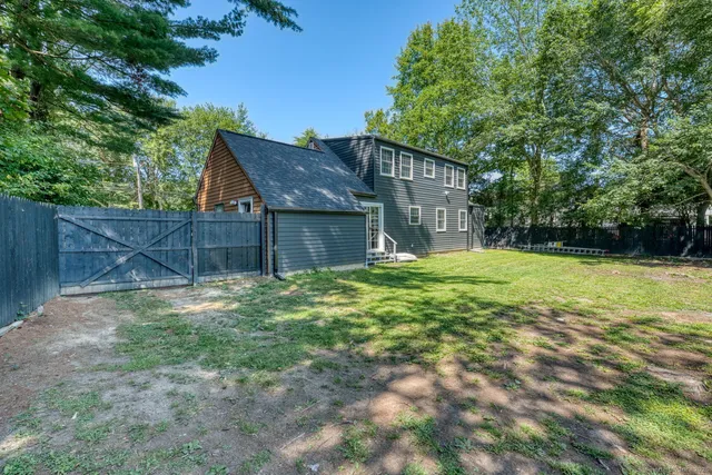 a view of a yard in front of a house with large tree
