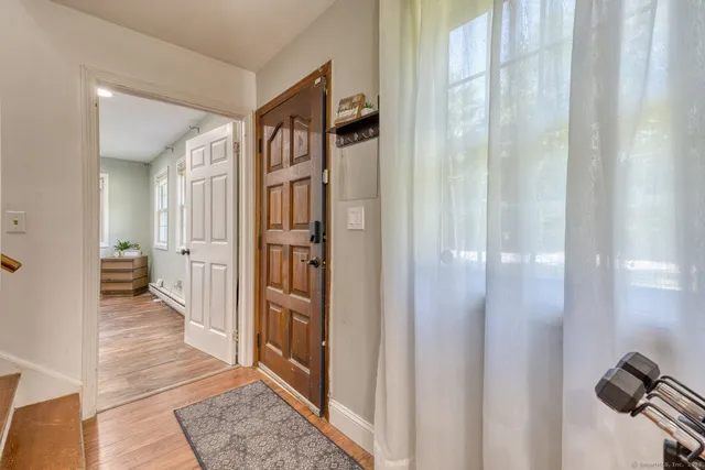 a view of a hallway with a livingroom and a glass door