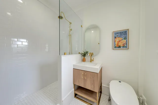 a bathroom with a toilet a sink and mirror