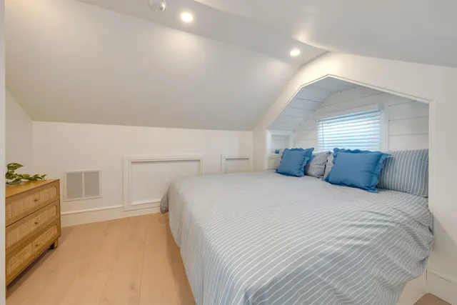 a view of a white house with large windows and a small yard