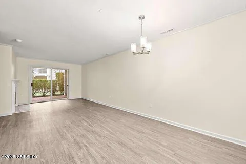 a view of empty room with wooden floor and window