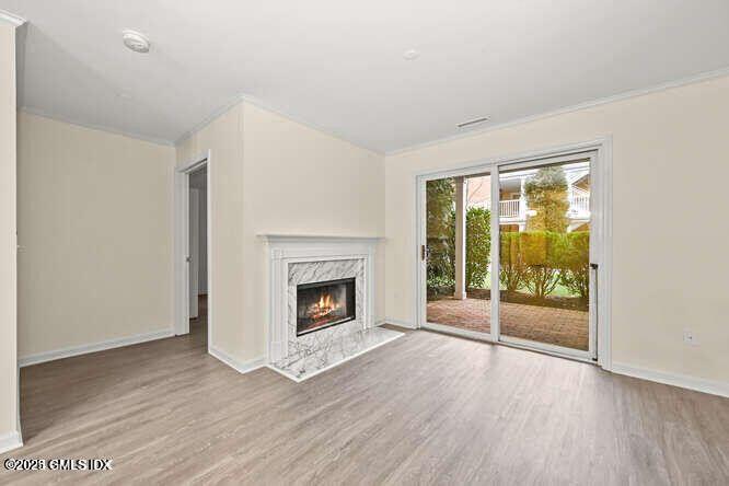51 Forest Avenue, Unit 147 Old Greenwich, CT 06870 - Photo 4 of 19 an empty room with wooden floor fireplace and windows