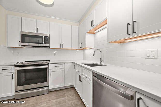 51 Forest Avenue, Unit 147 Old Greenwich, CT 06870 - Photo 6 of 19 a kitchen with white cabinets stainless steel appliances and sink