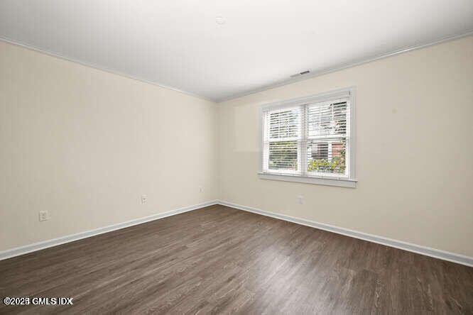 51 Forest Avenue, Unit 147 Old Greenwich, CT 06870 - Photo 8 of 19 an empty room with wooden floor and windows