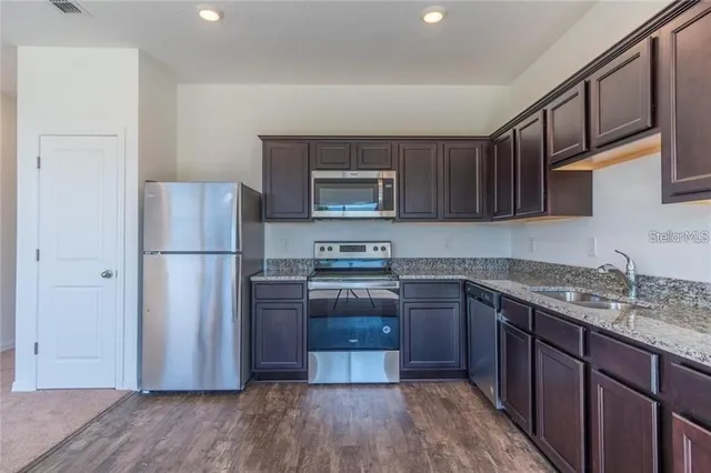 a kitchen with stainless steel appliances granite countertop a refrigerator stove a sink and dishwasher