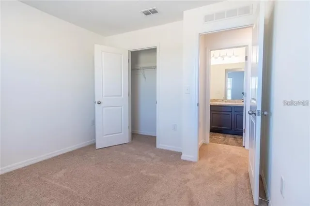 an empty room with a bathroom and mirror