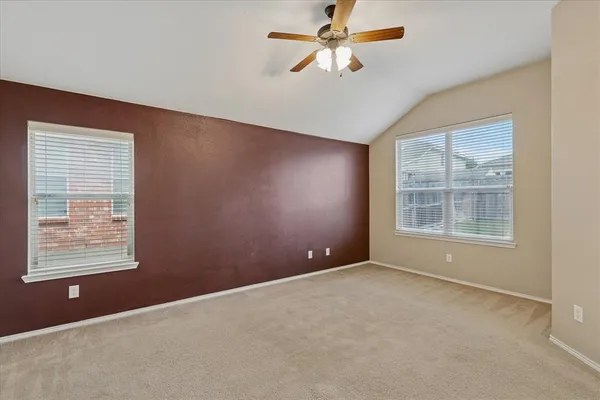 an empty room with windows and fan