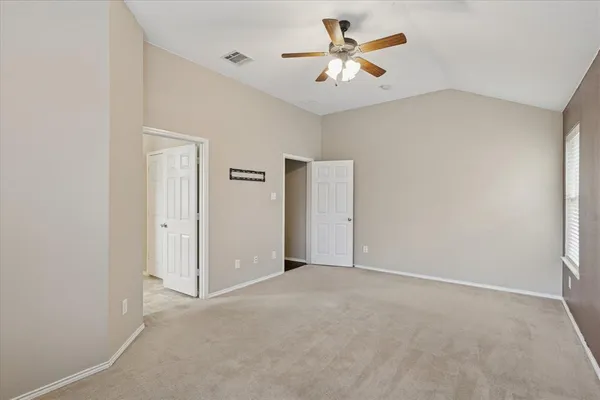 an empty room with closet and a chandelier fan