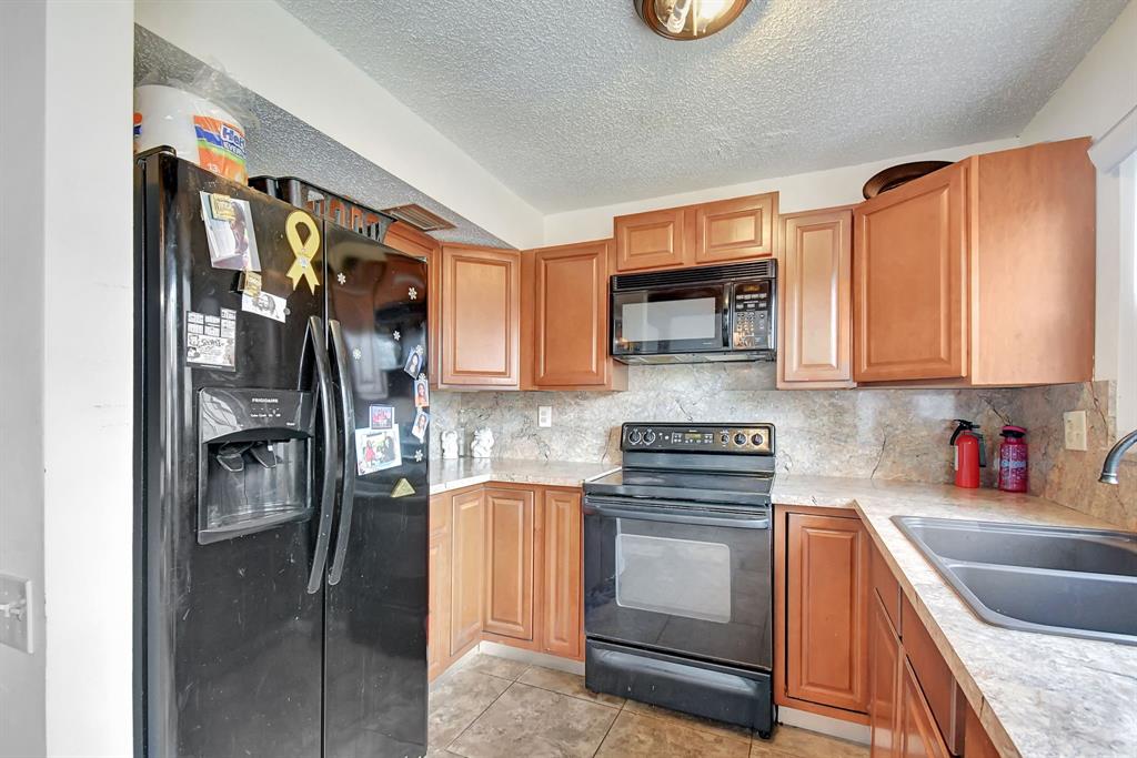 2420 Southwest 80th Terrace Miramar, FL 33025 - Photo 9 of 30 a kitchen with stainless steel appliances granite countertop a refrigerator and a stove top oven