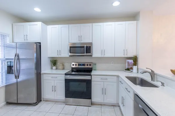 a kitchen with cabinets stainless steel appliances and a sink