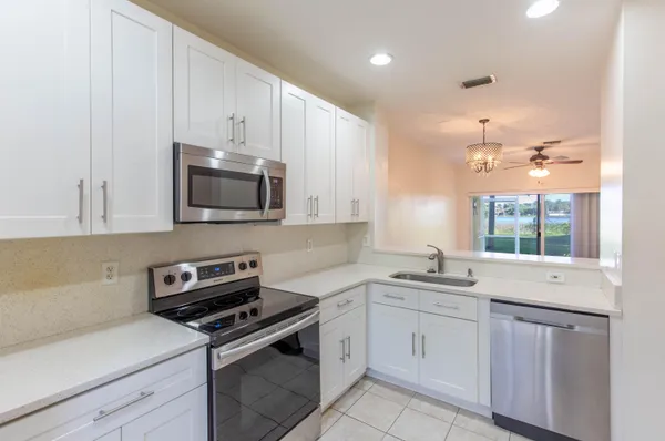 a kitchen with stainless steel appliances white cabinets and sink