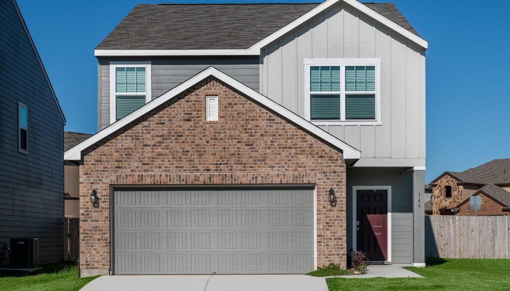 a front view of a house with a garden and plants