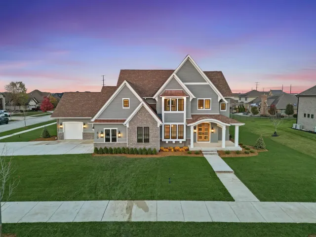 a front view of a house with a garden and yard