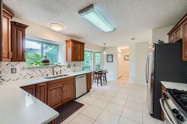 a kitchen with stainless steel appliances granite countertop a sink stove and refrigerator