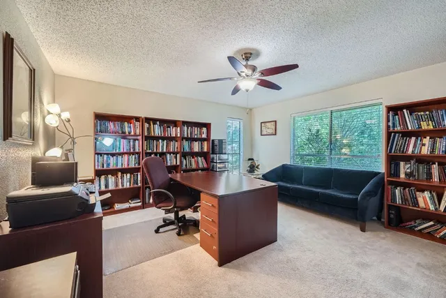 a view of a livingroom with workspace and a bookshelf