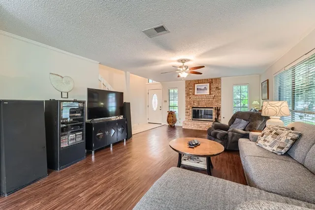 a living room with furniture a flat screen tv and kitchen view