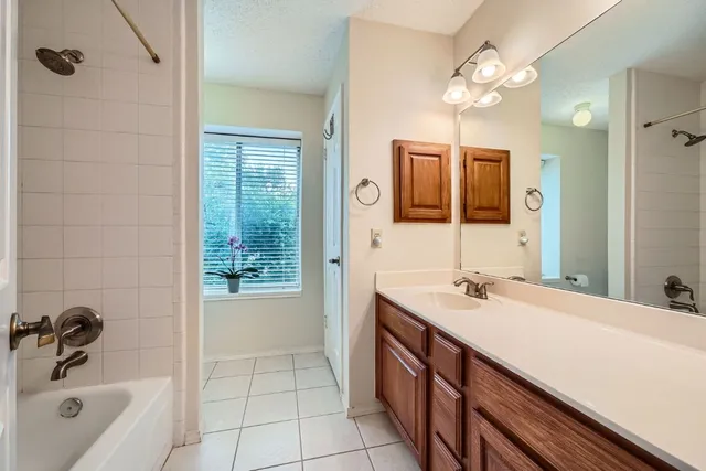 a bathroom with a sink a tub and a mirror