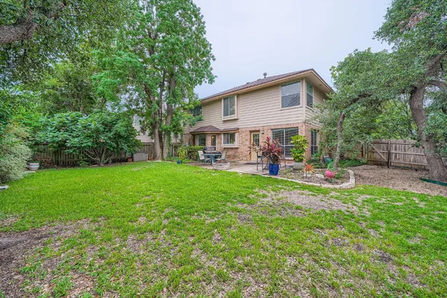 a view of a house with a backyard and a patio