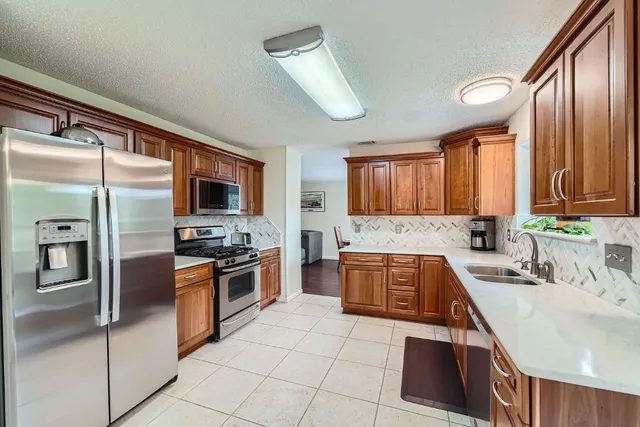 a kitchen with stainless steel appliances granite countertop a sink microwave and stove