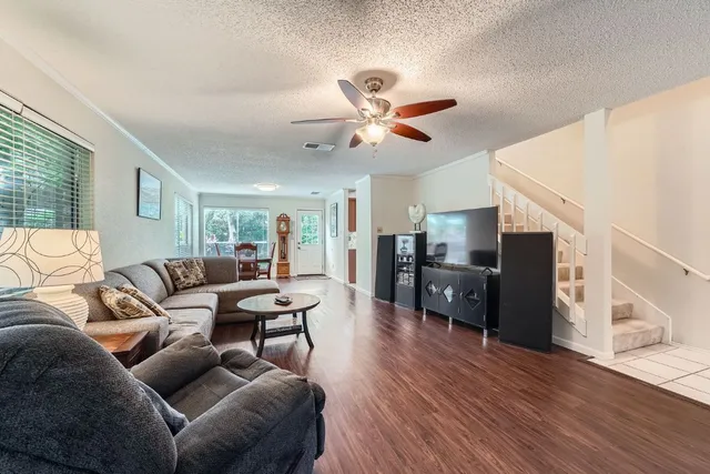 a living room with furniture and a wooden floor